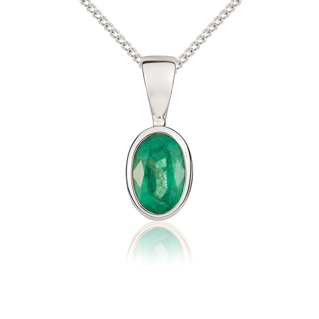 9ct white gold emerald pendant necklace featuring a 6x4mm oval-cut green emerald in a polished rubover setting, suspended from a delicate trace chain.