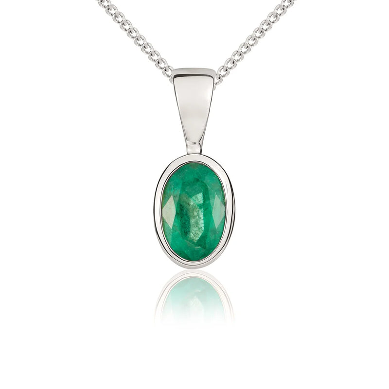9ct white gold emerald pendant necklace featuring a 6x4mm oval-cut green emerald in a polished rubover setting, suspended from a delicate trace chain.