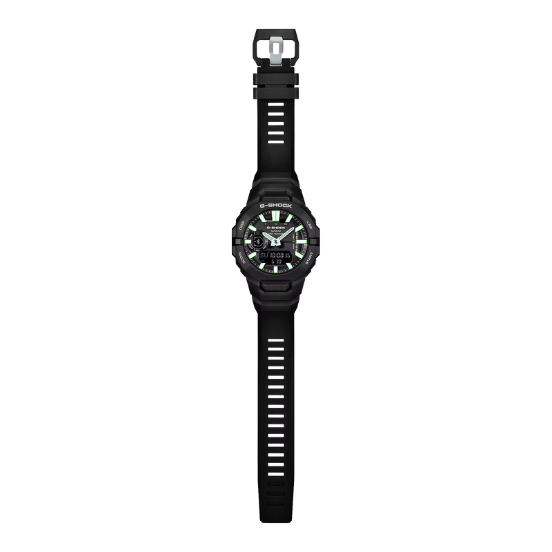 Full-length view of a black Casio G-SHOCK ana-digi watch with a black resin strap, green luminous hour markers, silver hands and digital display.