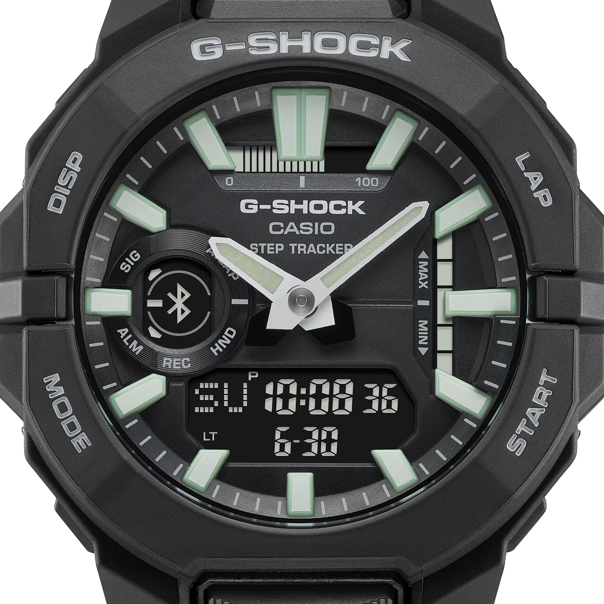 Close-up of a black Casio G-SHOCK ana-digi watch face featuring green luminous hour markers, silver hands, Bluetooth symbol, step tracker and digital display.