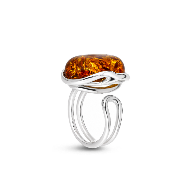Handmade sterling silver ring featuring a large oval orange Baltic amber stone with a flowing open band on a white background.
