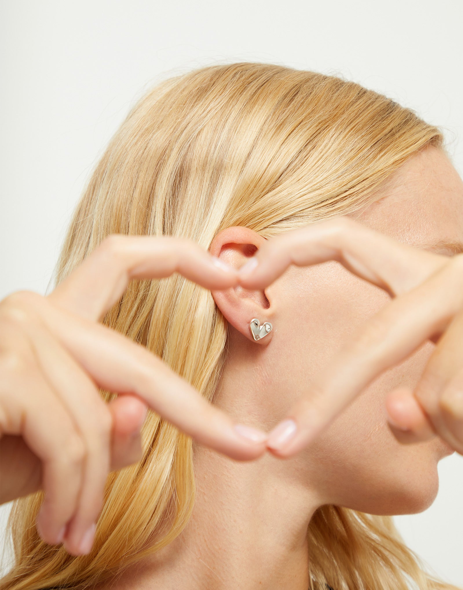 UNOde50 silver plated medium heart stud earrings front view with organic handcrafted heart design.