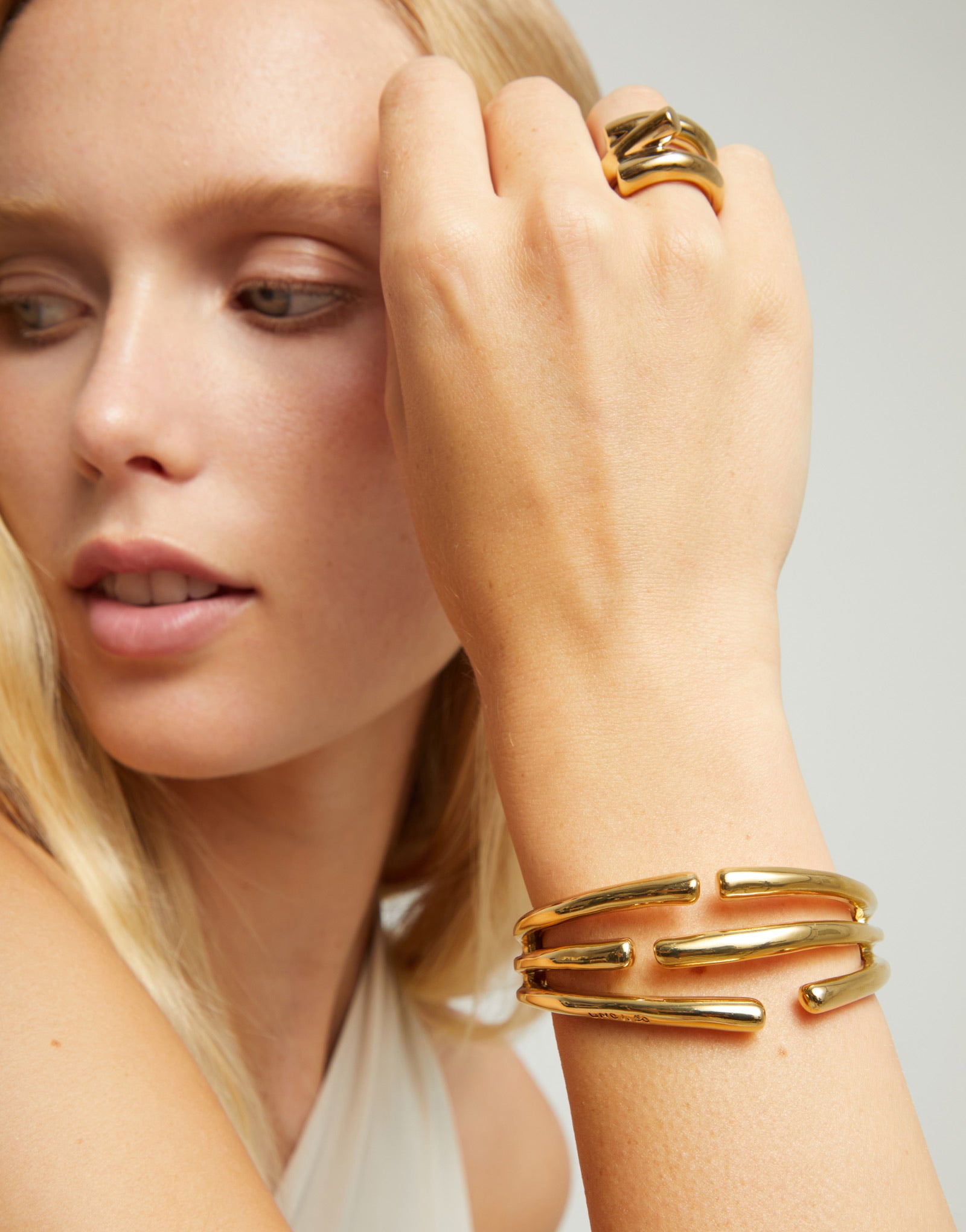 UNOde50 Organic gold plated three intertwined cuff bangle front angled view with sculptural open design.