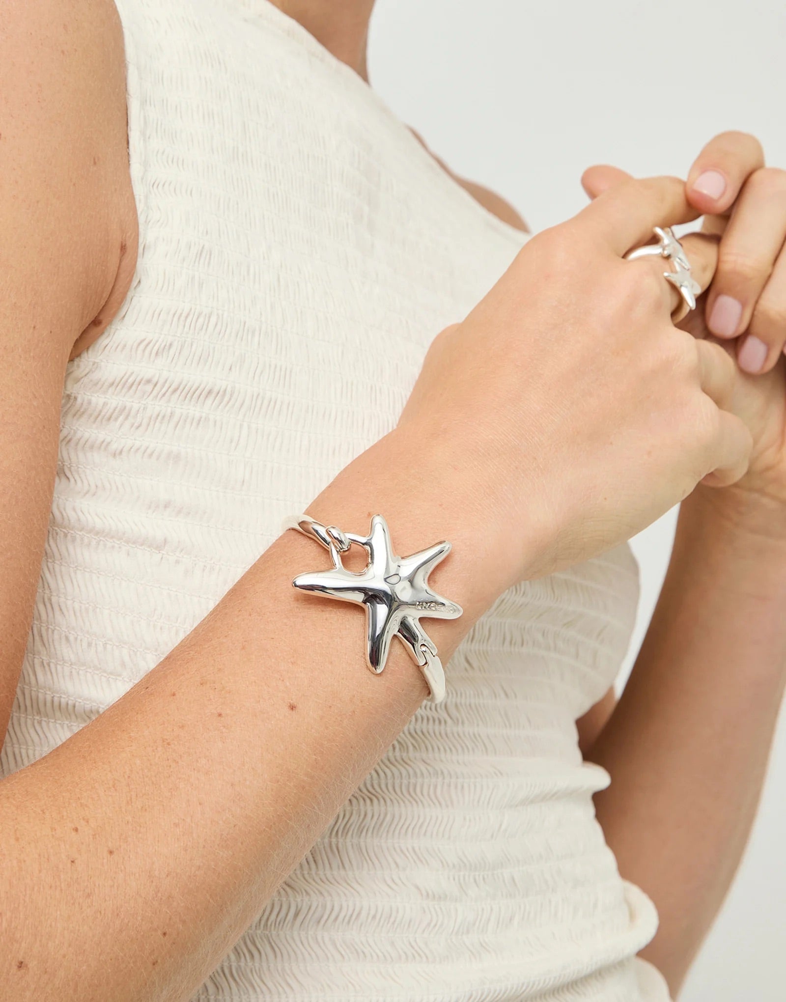 UNOde50 silver plated starfish charm bangle with polished organic starfish pendant, front view.