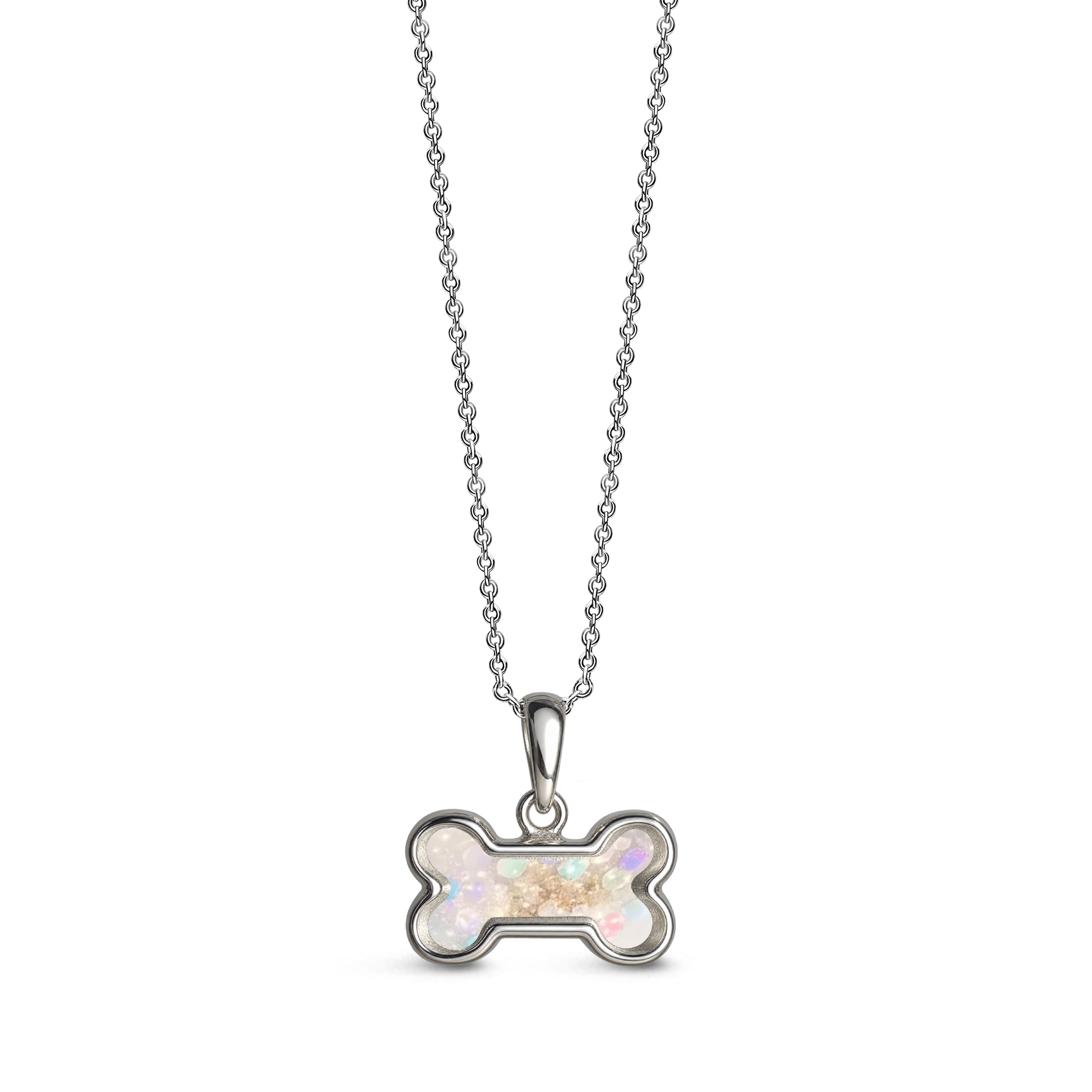 Sterling silver dog bone-shaped ashes keepsake pendant necklace featuring a opalite glitter memorial setting with incorporated ashes and a polished silver border.