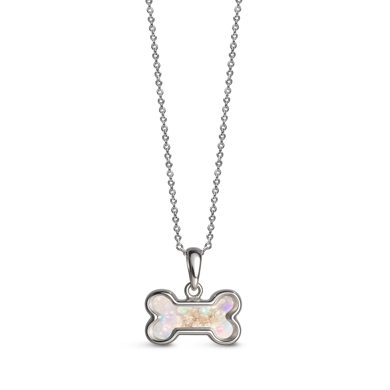 Sterling silver dog bone-shaped ashes keepsake pendant necklace featuring a opalite glitter memorial setting with incorporated ashes and a polished silver border.