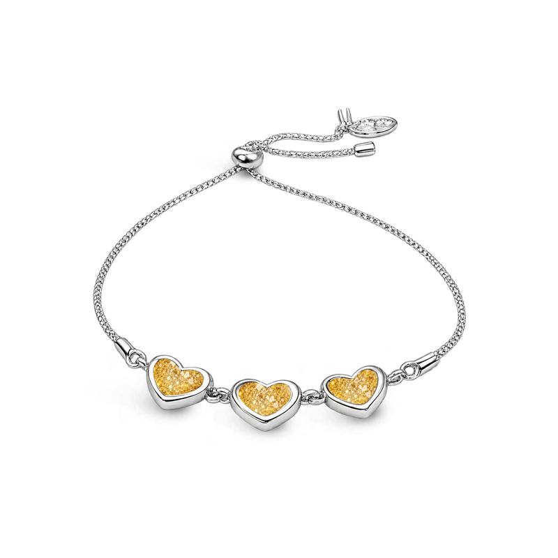 Sterling silver three-heart ashes keepsake bracelet featuring gold glitter memorial settings with incorporated ashes and an adjustable slider fastening.