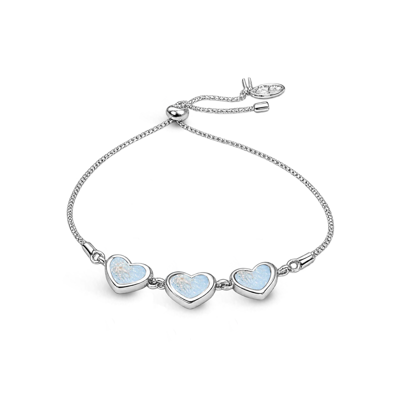Sterling silver three-heart ashes keepsake bracelet featuring baby blue glitter memorial settings with incorporated ashes and an adjustable slider fastening.