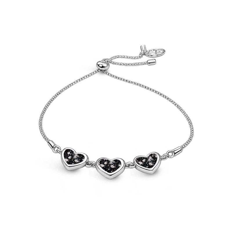 Sterling silver three-heart ashes keepsake bracelet featuring black glittering memorial settings with incorporated ashes and an adjustable slider fastening.
