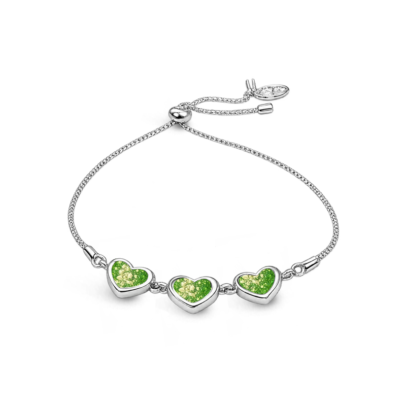 Sterling silver three-heart ashes keepsake bracelet featuring lime glitter memorial settings with incorporated ashes and an adjustable slider fastening.