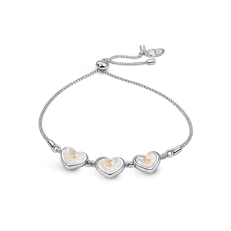 Sterling silver three-heart ashes keepsake bracelet featuring opalite glitter memorial settings with incorporated ashes and an adjustable slider fastening.