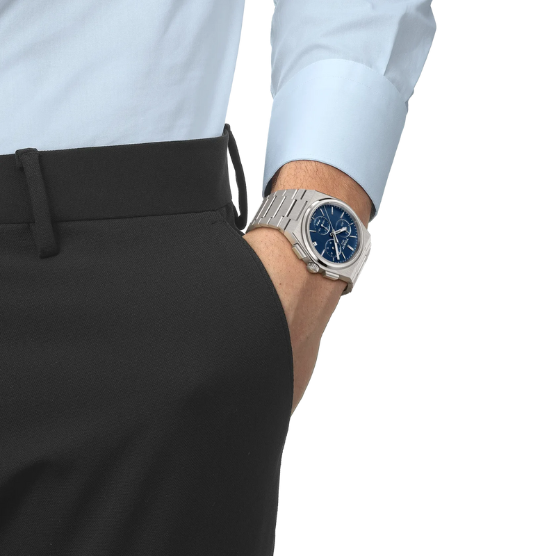 Tissot PRX chronograph watch with blue dial and stainless steel bracelet worn on wrist