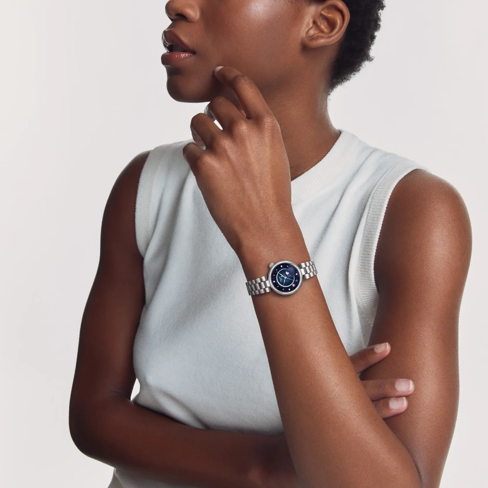 Woman wearing a Tissot watch with blue moonphase dial and stainless steel bracelet
